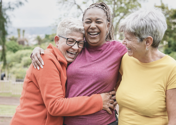image of three women laughing and hugging