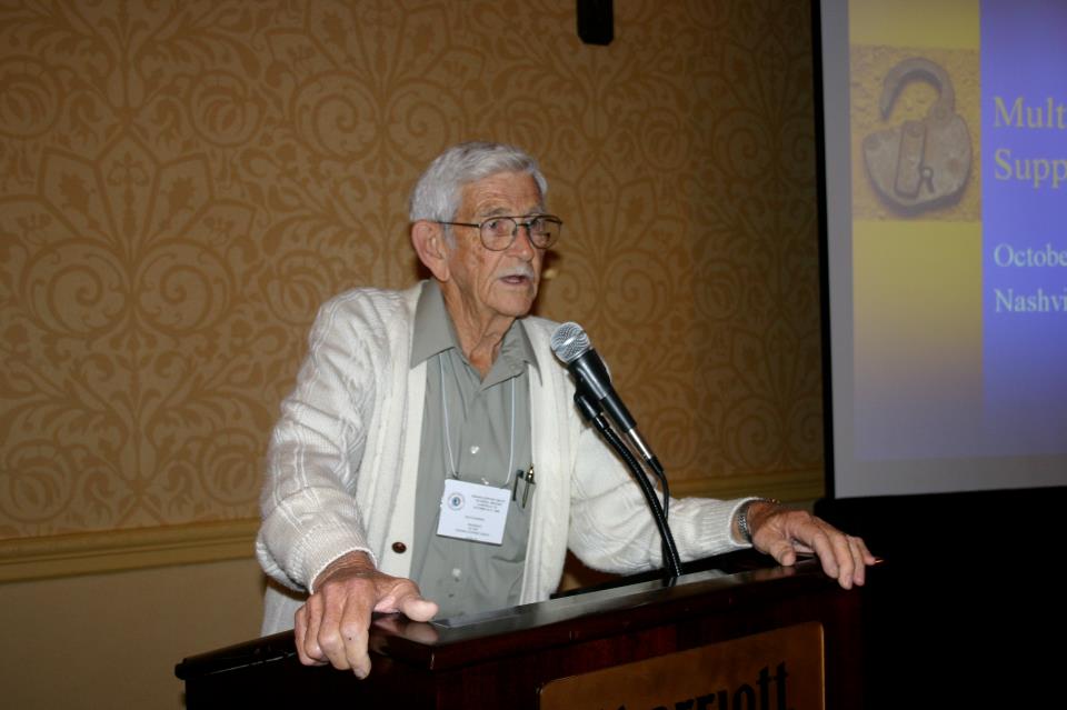 man speaking at a conference podium